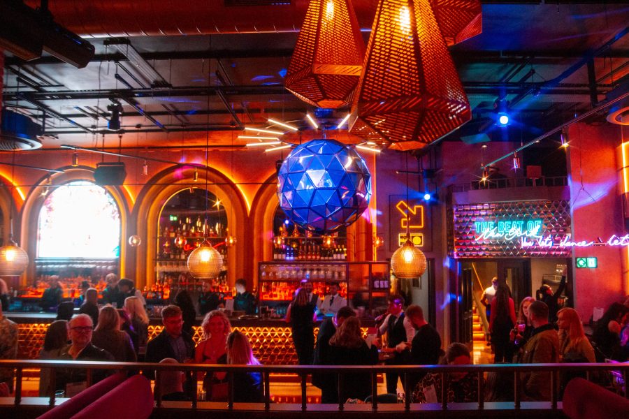 View of the Manahatta bar from its mezzanine. Warm colours, there is a giant disco mirror ball.